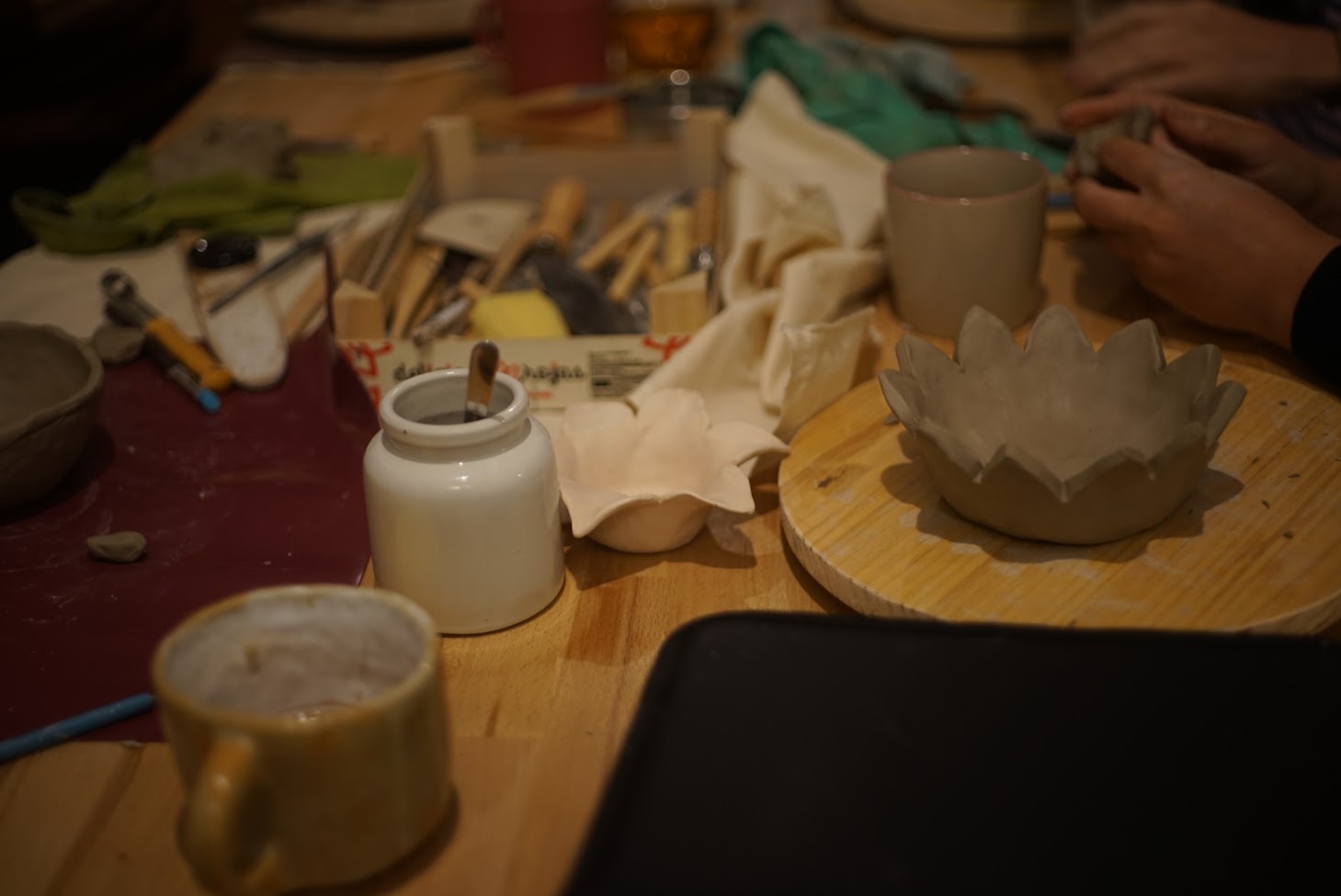 Multiple ceramic pieces taking shape across the studio table