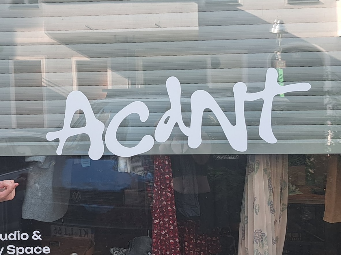 The ACDNT studio storefront window with its hand-lettered logo decal
